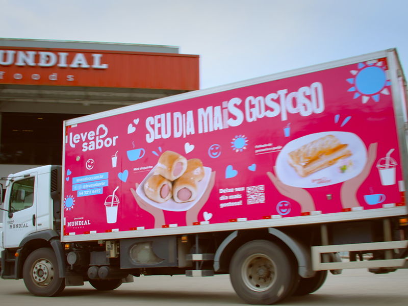 Fachada da fábrica da Mundial Foods em Caxias do Sul com caminhão refrigerado da Leve Sabor